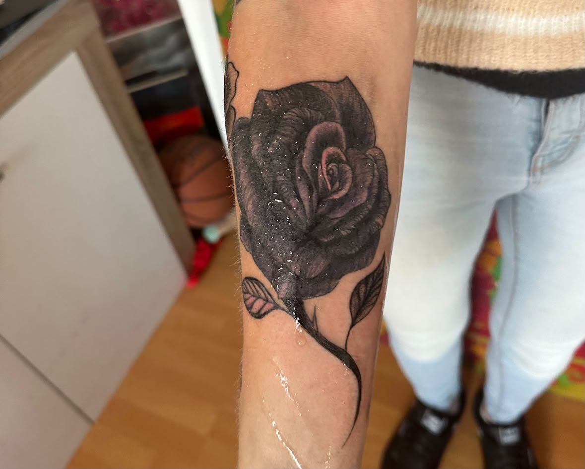 Realistische dunkle Rose am Unterarm