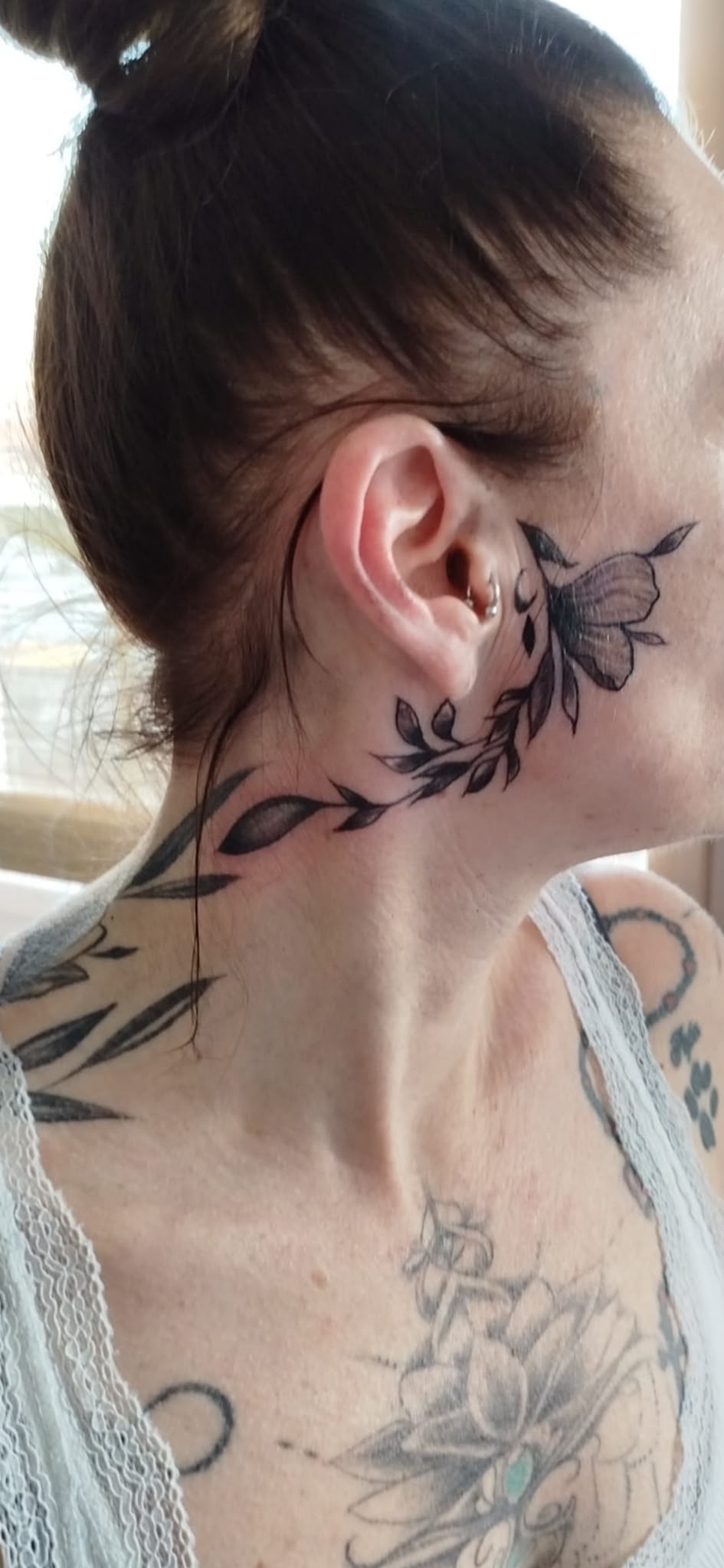 Feines Fine-Line-Blumen-Tattoo im Nacken